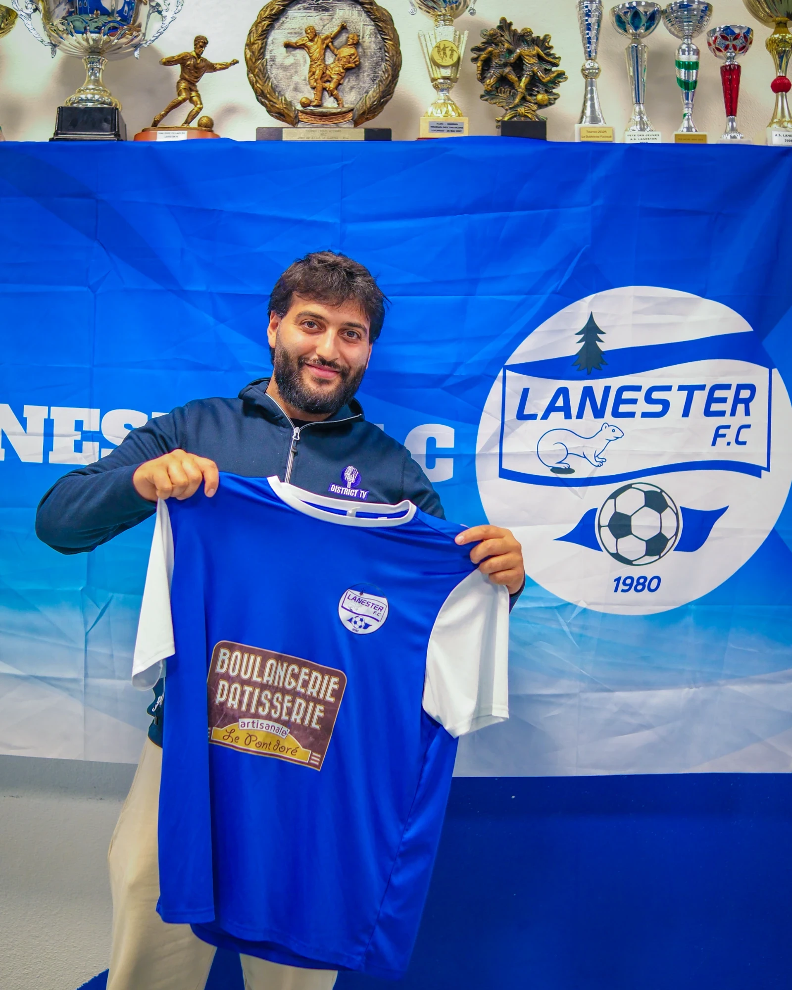 District TV au Lanester FC : le maillot du club présenté devant sa bannière et ses trophées