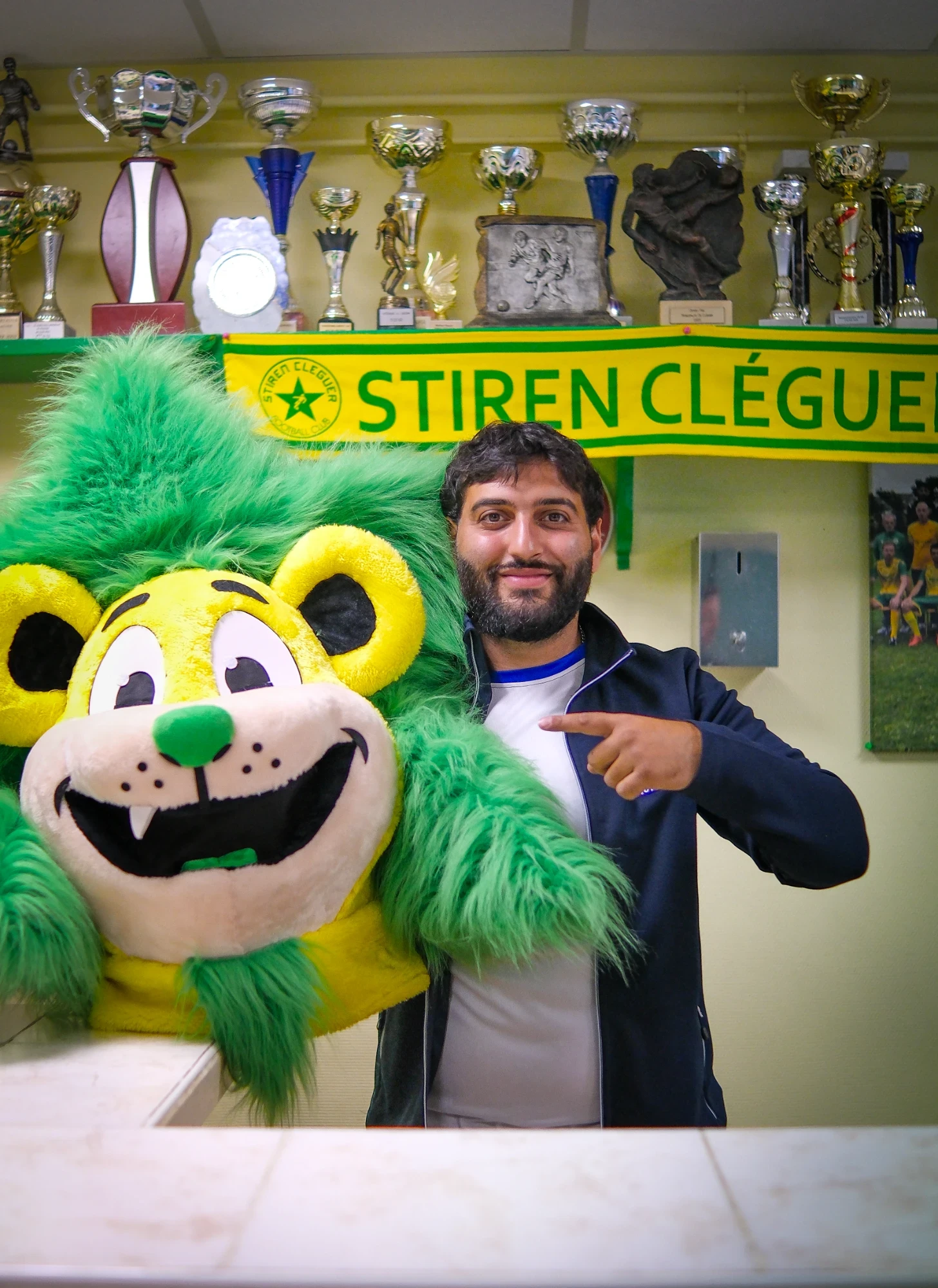 District TV à la Stiren Cléguer : pose avec la mascotte du club, sous les trophées